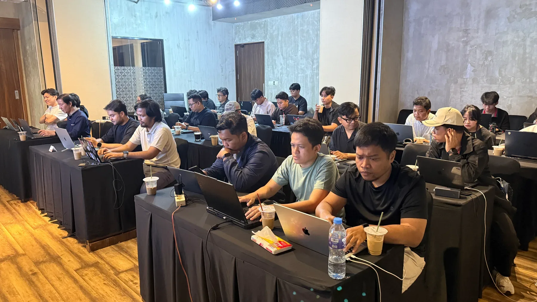 Participants building on laptops around a table