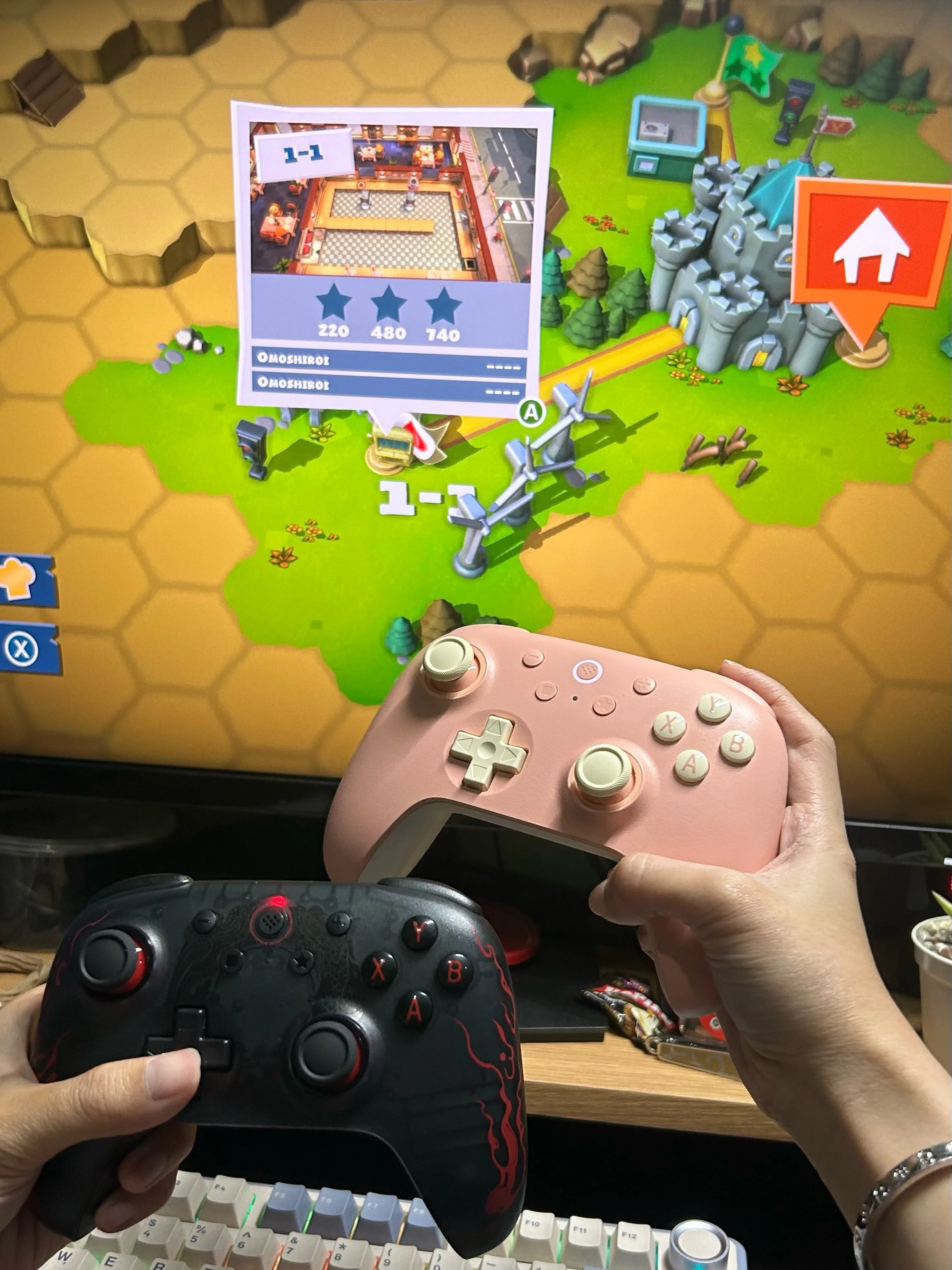 Two game controllers in front of a screen